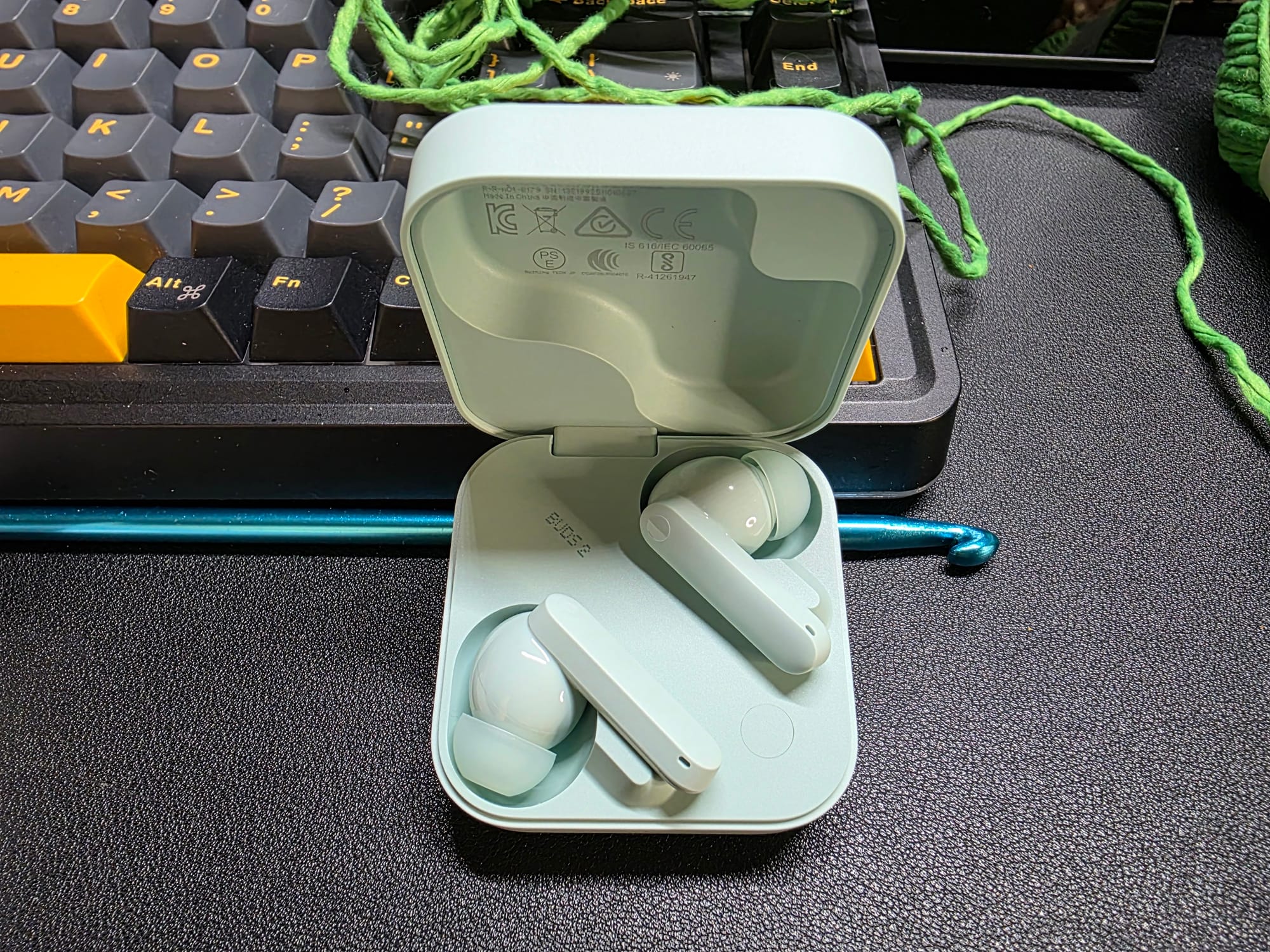 The CMF Buds 2 are in their open case. They are pale green to match the case.