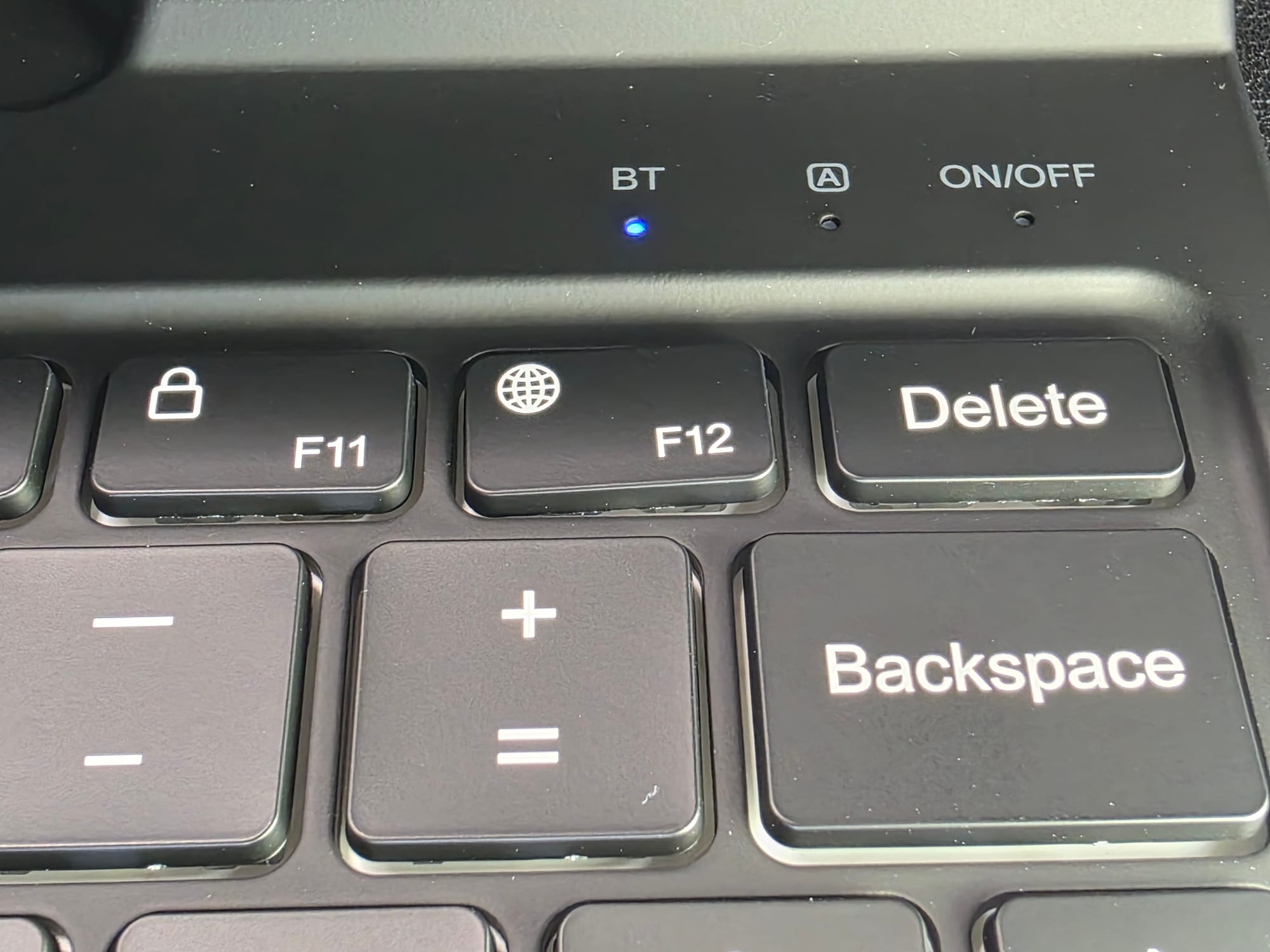 A close-up photo of the top right of the keyboard reveals an F12 key that is crooked. It still works fine, though.