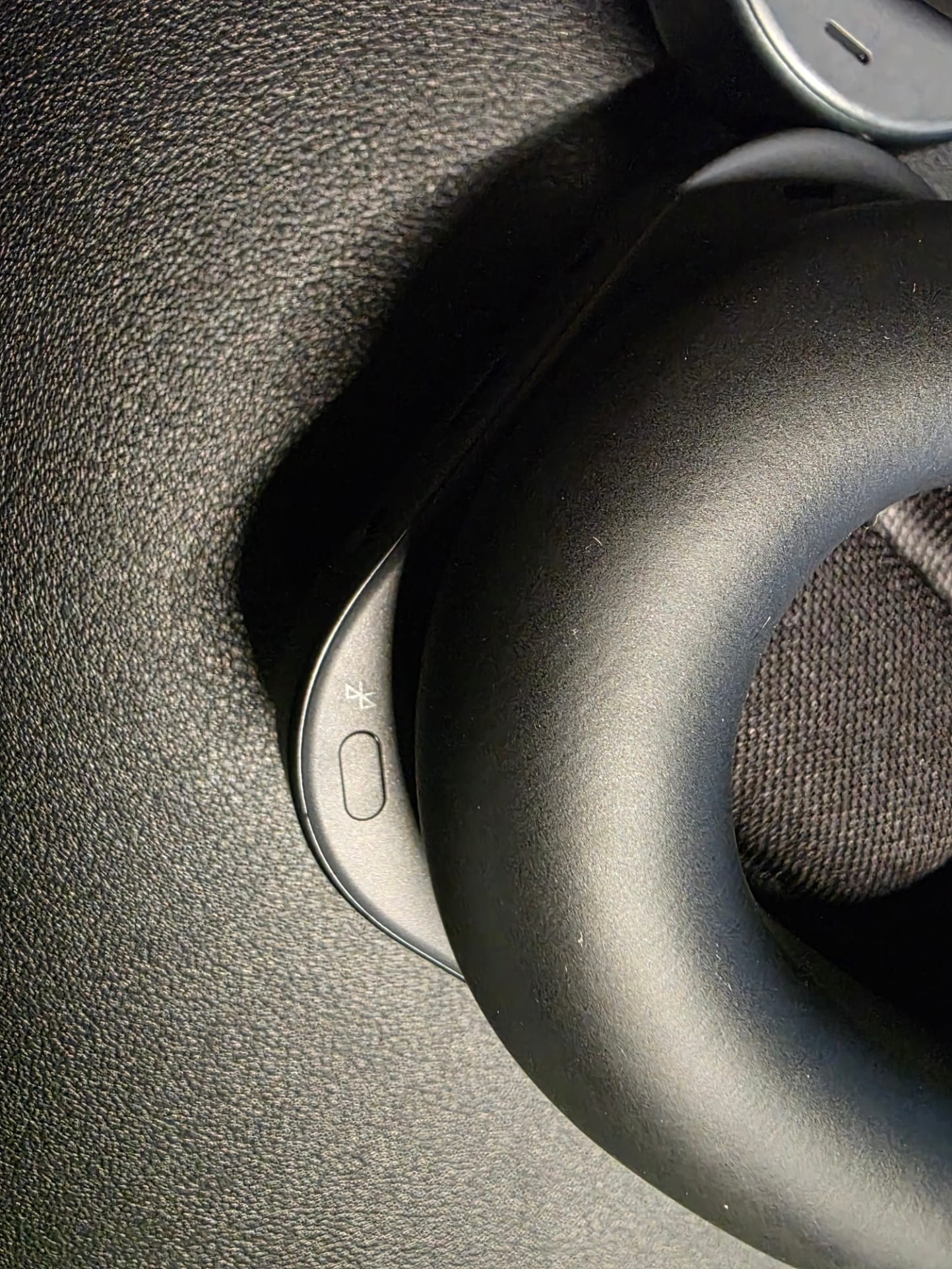 Photo shows close-up of the Bluetooth pairing button on the inside of the right earcup