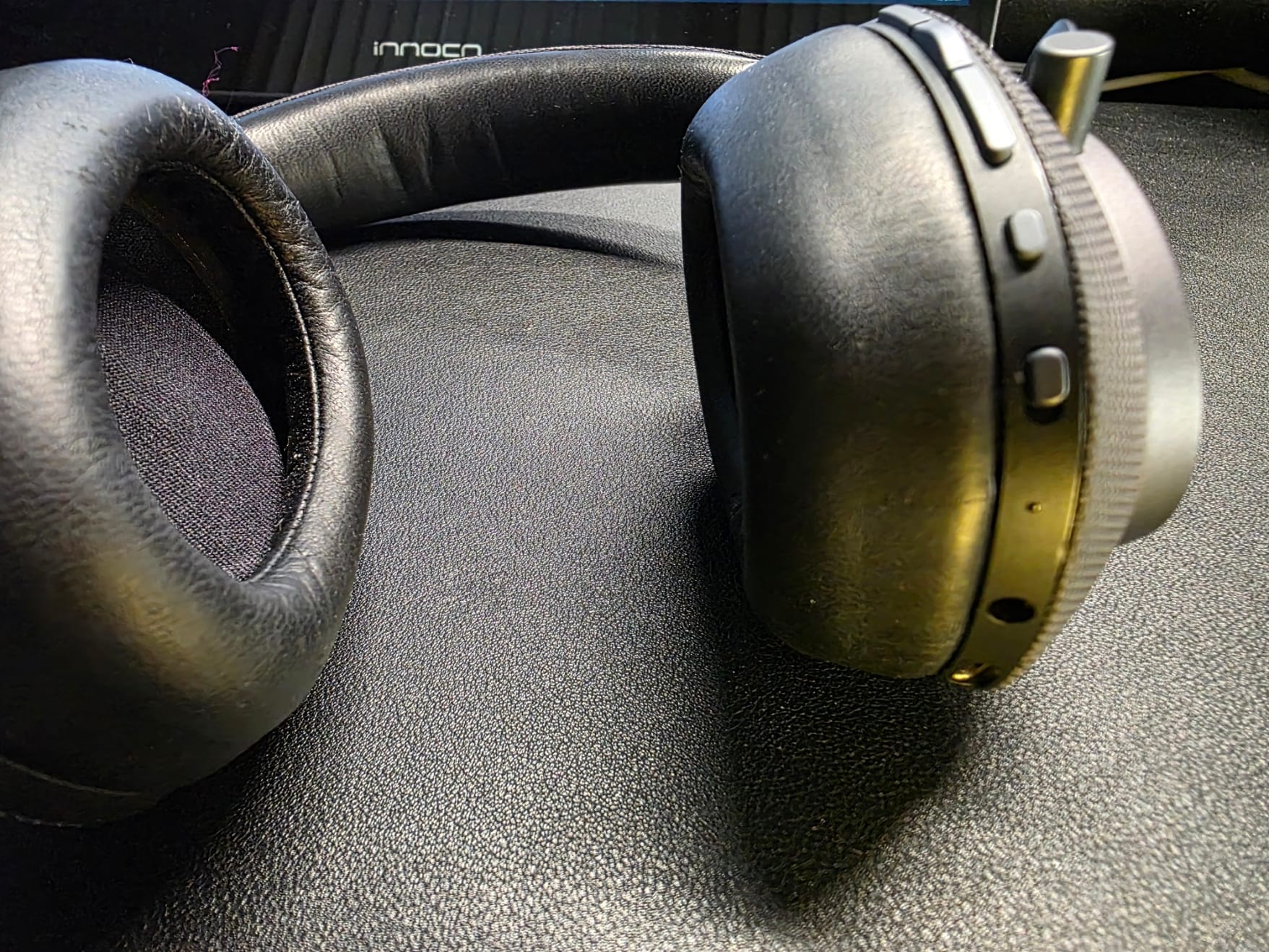 The PX is laying down with earcups turned in, showing the buttons and ports on the right earcup