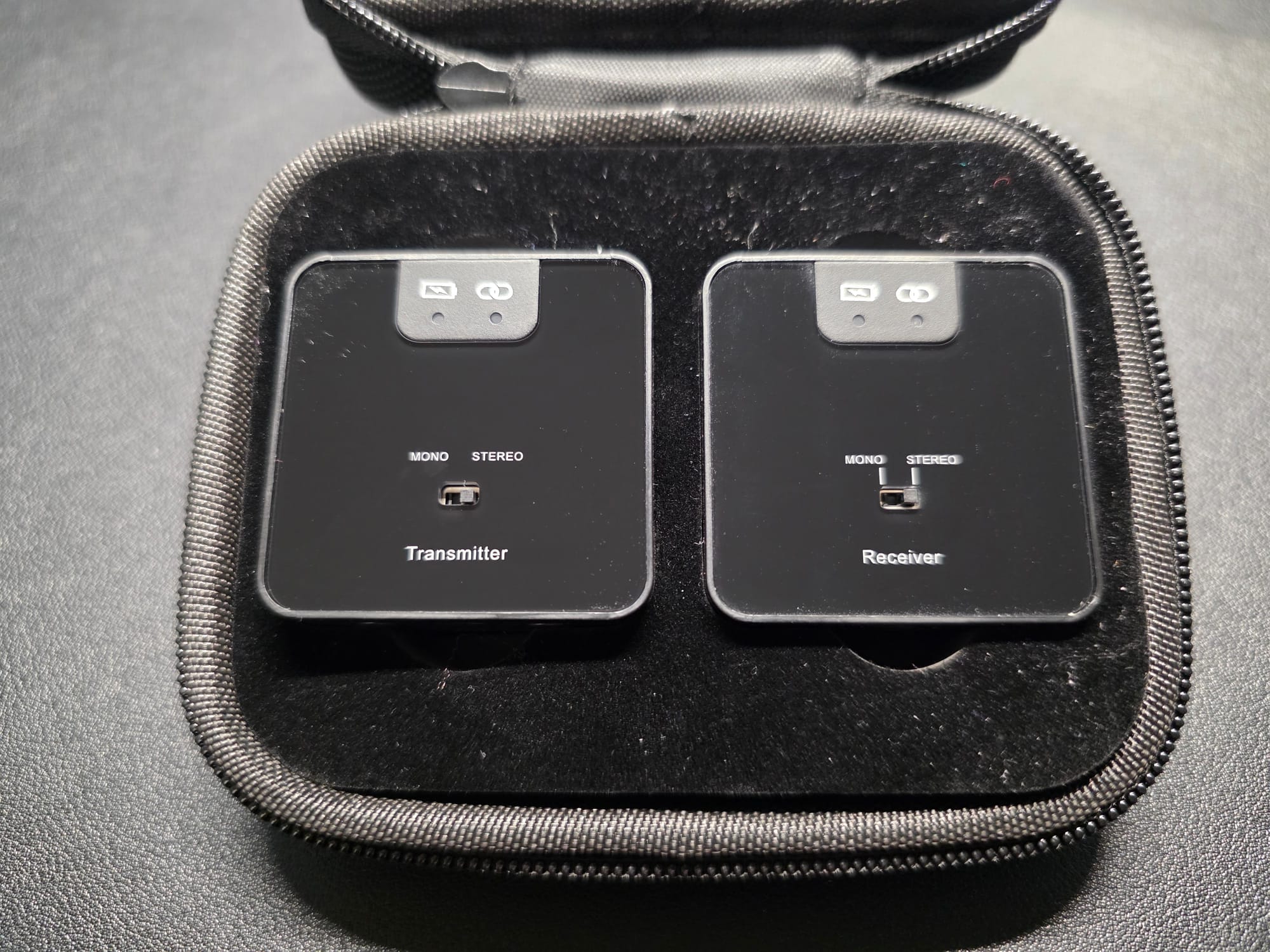 The Accessport Pro transmitter and receiver in their included case. The case is black and is open displaying the devices next to each other.