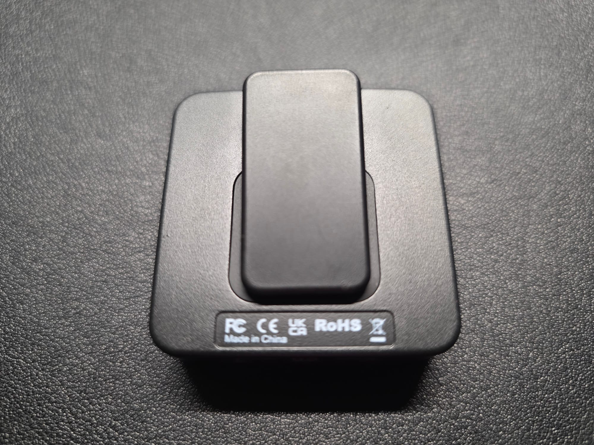 The rear of the Accessport Pro. It is lying flat on a black desk.