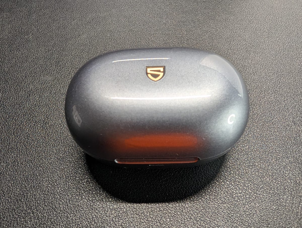 The SoundPeats Clip 1 closed in their shiny gray case with the stylized S logo on the top