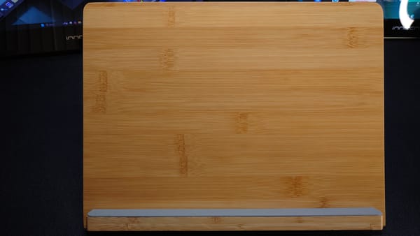 Photo of a wooden tablet stand with a gray rubber base for the tablet to sit on