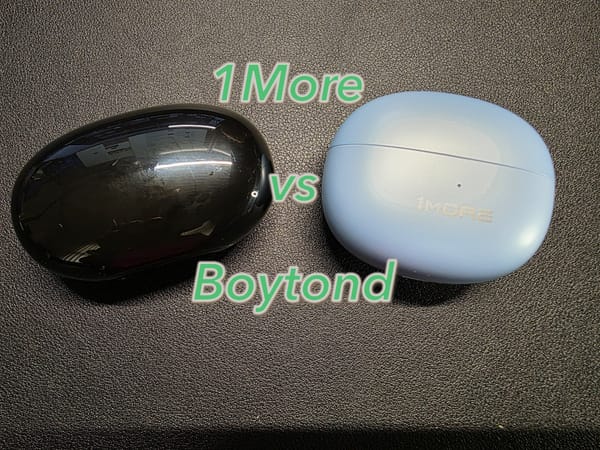Boytond YYK-S19 in black on the left and the 1More S20 in blue on the right.  Closed cases are on a black desk.