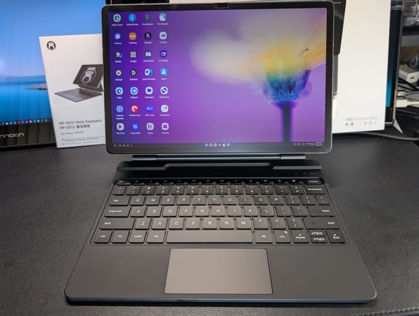 The Mofa keyboard case pictured on a black desk with the manual and box in the background.  My S10+ is mounted in the case showing a yellow flower on a purple backdrop.