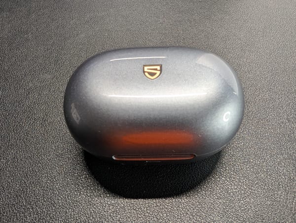 The SoundPeats Clip 1 closed in their shiny gray case with the stylized S logo on the top